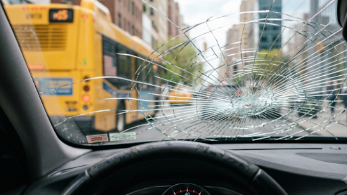 Cracked car windshield viewed from driver's seat.